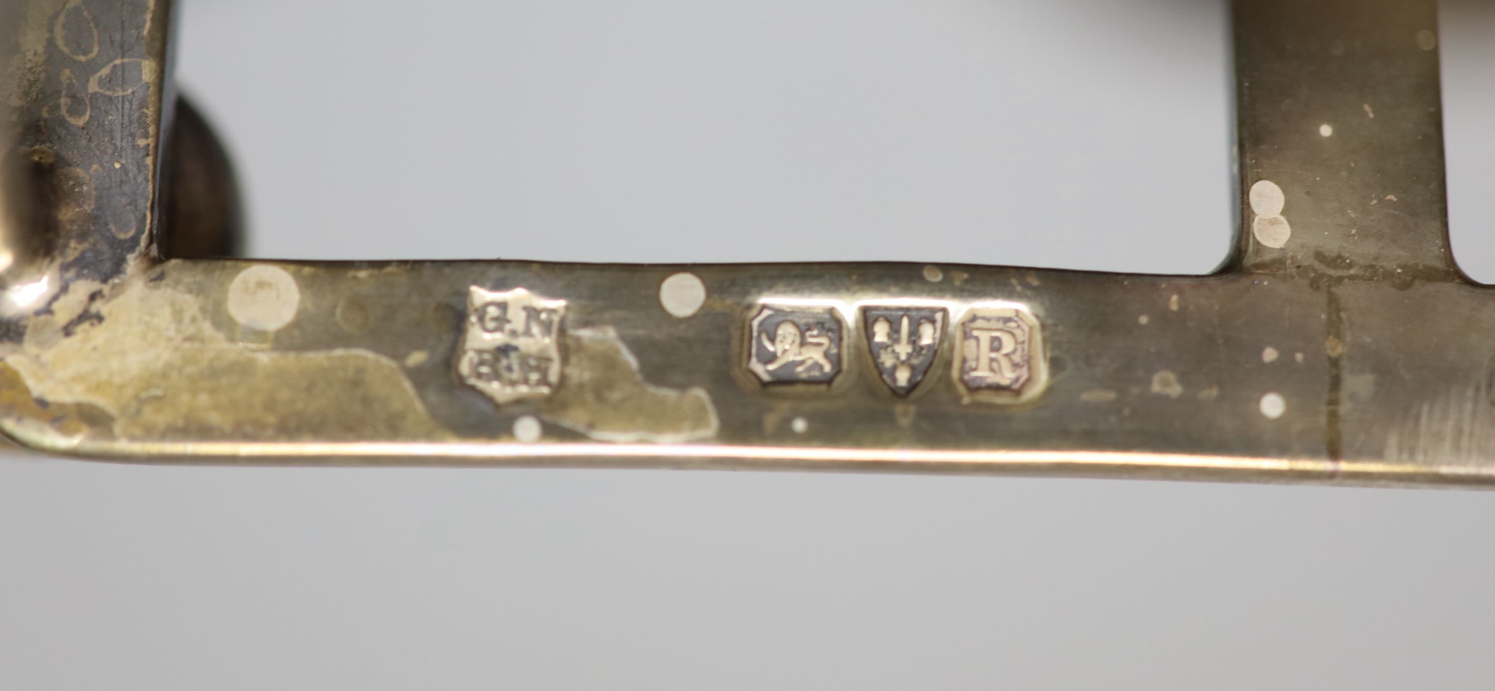 A late Victorian silver seven bar toastrack, on bun feet, Nathan & Hayes, Chester, 1900, length 13.6cm,